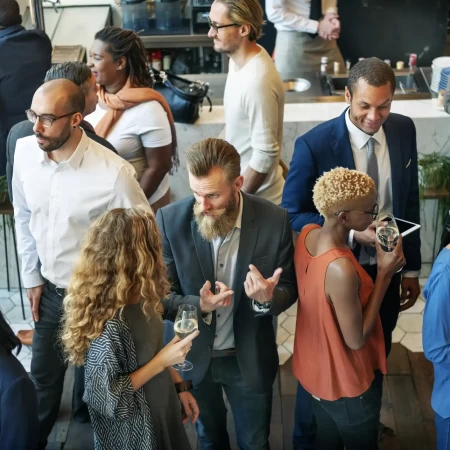 Imagem de um grupo diversificado de pessoas envolvidas em uma discussão animada, representando uma aula de ESL sobre networking.